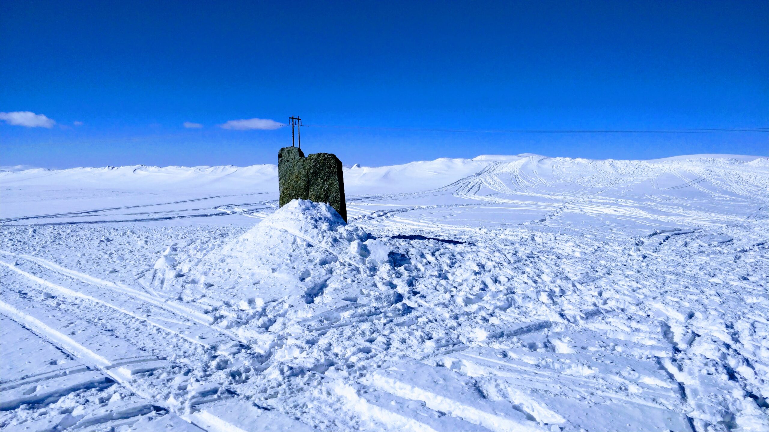 Flatruets röse med vit snö på marken och blå himmel i bakgrunden.